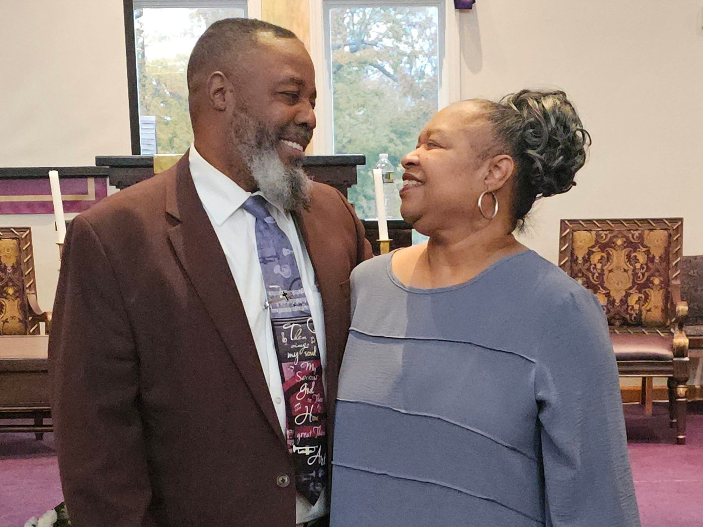 Pastor LeeArtis Nevith and First Lady Linda Nevith smiling at each other in the sanctuary