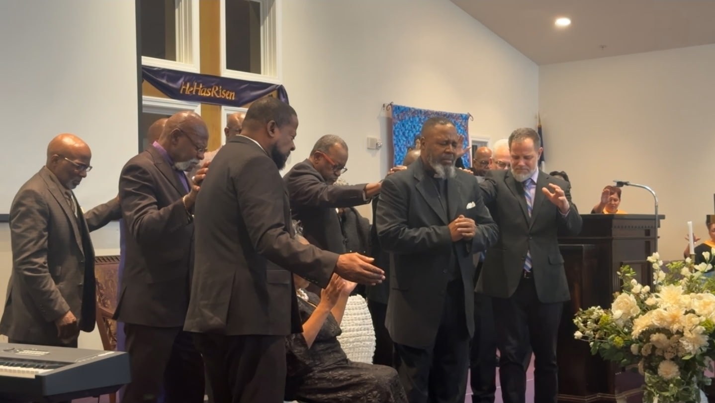Church leaders lay hands on Pastor LeeArtis Nevith in prayer during his installation service